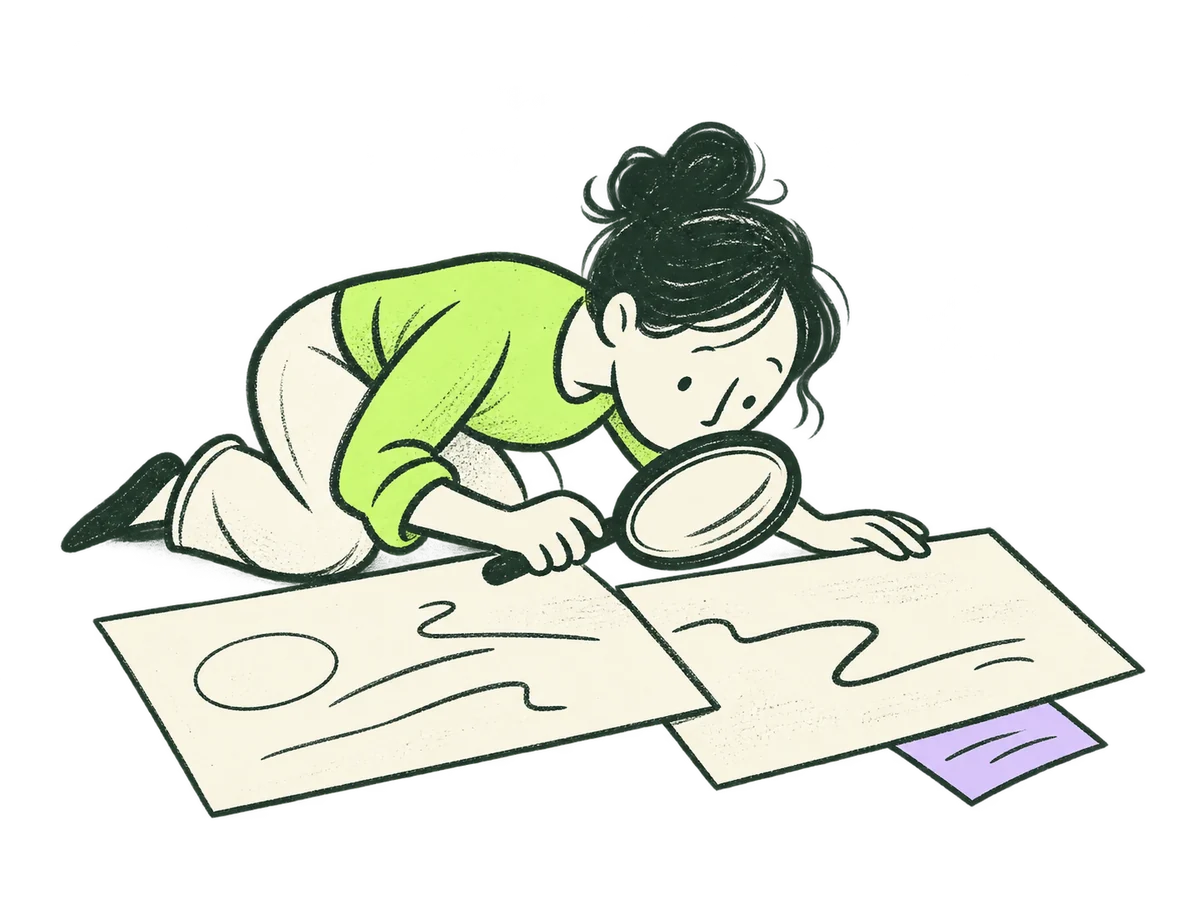 A person uses a magnifying lens to examine and compare two evidence cards.